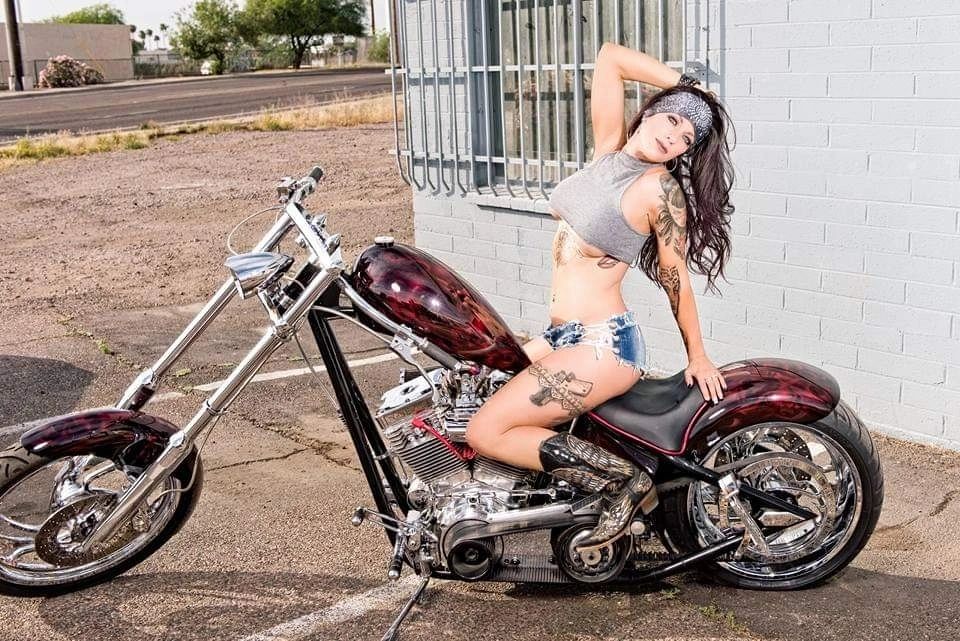 Rider posing on a custom chopper motorcycle outdoors wearing Marie's handcrafted headband