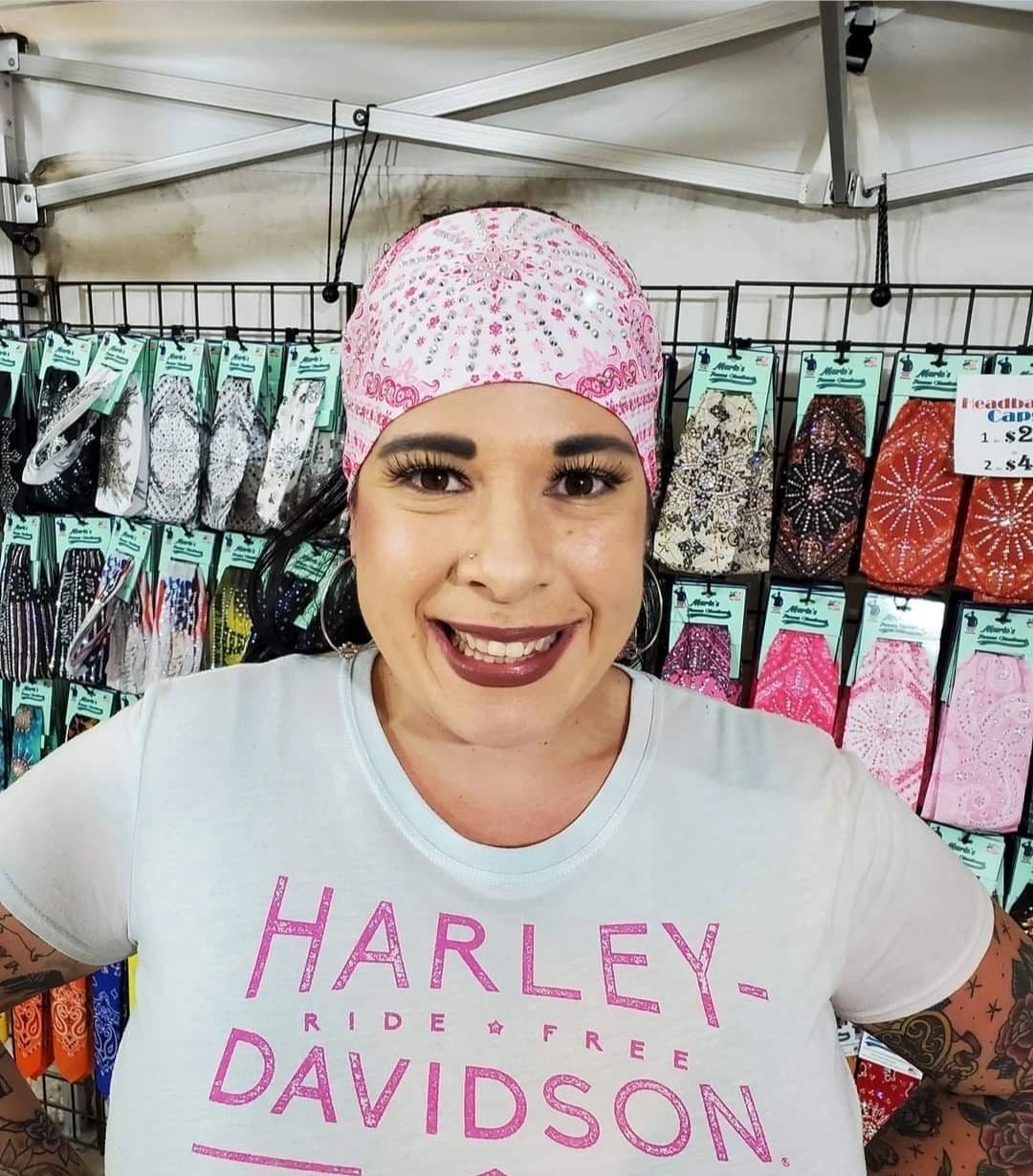 Smiling rider wearing pink rhinestone headband at motorcycle rally event